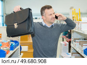 salesman raising his arms in frustration while on telephone. Стоковое фото, агентство Ingram Publishing / Фотобанк Лори