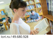 woman reading a book in the library. Стоковое фото, агентство Ingram Publishing / Фотобанк Лори