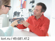 optician showing equipment to patient. Стоковое фото, агентство Ingram Publishing / Фотобанк Лори