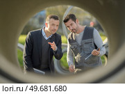 workers talking through a precast concrete pipe. Стоковое фото, агентство Ingram Publishing / Фотобанк Лори