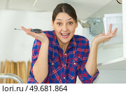 woman shrugging while trying to fit kitchen cupboard. Стоковое фото, агентство Ingram Publishing / Фотобанк Лори