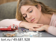 depressed teenage girl looking at her smoking equipment. Стоковое фото, агентство Ingram Publishing / Фотобанк Лори