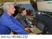 auto mechanic teacher and trainee performing tests at mechanic school. Стоковое фото, агентство Ingram Publishing / Фотобанк Лори