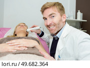 doctor using electric device on female patients chin. Стоковое фото, агентство Ingram Publishing / Фотобанк Лори