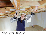 young gorgeous woman pulling to the ceiling in repair. Стоковое фото, агентство Ingram Publishing / Фотобанк Лори