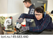 coachbuilding taining girl standing in garage. Стоковое фото, агентство Ingram Publishing / Фотобанк Лори