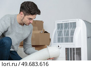 Man fitting hose to ventilation system. Стоковое фото, агентство Ingram Publishing / Фотобанк Лори