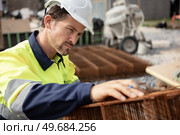 builder in uniform and white helmet working on building foundation. Стоковое фото, агентство Ingram Publishing / Фотобанк Лори
