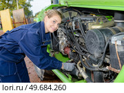 female auto mechanic fixing the engine of a car outdoors. Стоковое фото, агентство Ingram Publishing / Фотобанк Лори
