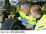 engineer checking tread on aircraft landing gear. Стоковое фото, агентство Ingram Publishing / Фотобанк Лори
