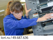 Female operative setting up machine. Стоковое фото, агентство Ingram Publishing / Фотобанк Лори