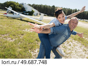 man giving his girlfriend piggyback arms outstretched like an aircraft. Стоковое фото, агентство Ingram Publishing / Фотобанк Лори