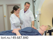Medical workers reassuring patient entering mri scanner. Стоковое фото, агентство Ingram Publishing / Фотобанк Лори