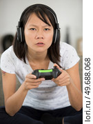 beautiful young asian woman engrossed in a computer game. Стоковое фото, агентство Ingram Publishing / Фотобанк Лори