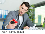 male office worker shock expression looking at alarm clock. Стоковое фото, агентство Ingram Publishing / Фотобанк Лори
