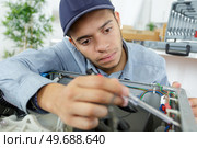 a young serviceman testing appliance. Стоковое фото, агентство Ingram Publishing / Фотобанк Лори