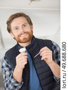 man holding a lightbulb and a screwdriver. Стоковое фото, агентство Ingram Publishing / Фотобанк Лори