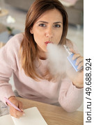 pretty woman smoking an electronic cigarette. Стоковое фото, агентство Ingram Publishing / Фотобанк Лори