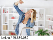 tired woman painting the ceiling overhead. Стоковое фото, агентство Ingram Publishing / Фотобанк Лори