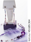 trendy author necklace with rarely gemstone charoite and earrings  around white background. fashion and handmade concept. Стоковое фото, агентство Ingram Publishing / Фотобанк Лори