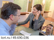 pretty seller helping choosing glasses in optics store. Стоковое фото, агентство Ingram Publishing / Фотобанк Лори