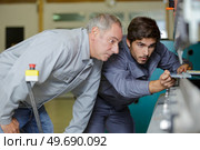 metal craftsman teaching know-how to young man. Стоковое фото, агентство Ingram Publishing / Фотобанк Лори