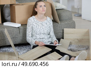 girl with difficulty assembling the furniture. Стоковое фото, агентство Ingram Publishing / Фотобанк Лори