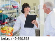 Senior couple in laundrette holding clipboard. Стоковое фото, агентство Ingram Publishing / Фотобанк Лори