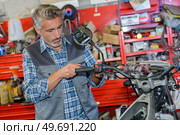 motorbike tire replacement installation in garage. Стоковое фото, агентство Ingram Publishing / Фотобанк Лори