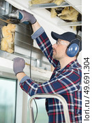 man using a grinder on a window. Стоковое фото, агентство Ingram Publishing / Фотобанк Лори