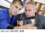 instructor and apprentice looking at belt. Стоковое фото, агентство Ingram Publishing / Фотобанк Лори