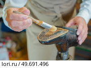 Cobbler gluing a shoe. Стоковое фото, агентство Ingram Publishing / Фотобанк Лори