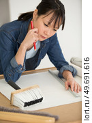 woman is gluing wallpaper on the wall. Стоковое фото, агентство Ingram Publishing / Фотобанк Лори