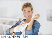 woman rubbing paint off of her arm after decorating. Стоковое фото, агентство Ingram Publishing / Фотобанк Лори