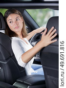 young woman driver turning back. Стоковое фото, агентство Ingram Publishing / Фотобанк Лори