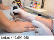 close up of hand applying a small tattoo. Стоковое фото, агентство Ingram Publishing / Фотобанк Лори