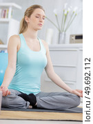 beautiful woman meditating at home in the lotus position. Стоковое фото, агентство Ingram Publishing / Фотобанк Лори