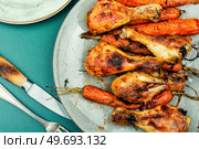 Appetizing chicken legs baked with vegetables. Homemade barbecue. Baked chicken drumstick, legs with carrots. Стоковое фото, агентство Ingram Publishing / Фотобанк Лори