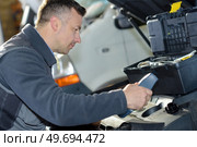 car mechanic replacing oil on engine in garage. Стоковое фото, агентство Ingram Publishing / Фотобанк Лори