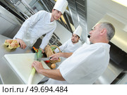 chef talking to trainees while demonstration how to chop leeks. Стоковое фото, агентство Ingram Publishing / Фотобанк Лори