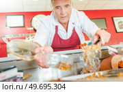 a work is scooping a meal. Стоковое фото, агентство Ingram Publishing / Фотобанк Лори