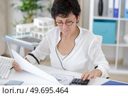 woman with casual clothing with laptop and paper worksheet. Стоковое фото, агентство Ingram Publishing / Фотобанк Лори