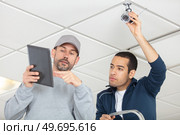2 professionals cctv technicians working. Стоковое фото, агентство Ingram Publishing / Фотобанк Лори