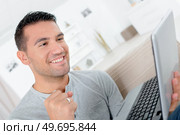 a triumphant man holding laptop. Стоковое фото, агентство Ingram Publishing / Фотобанк Лори