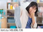 young woman disgusted by stinky sock. Стоковое фото, агентство Ingram Publishing / Фотобанк Лори