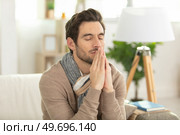 religious young man praying to god at home. Стоковое фото, агентство Ingram Publishing / Фотобанк Лори