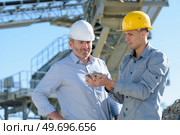 manager and worker with safety helmet outside a factory. Стоковое фото, агентство Ingram Publishing / Фотобанк Лори