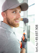 construction worker using drill to install window. Стоковое фото, агентство Ingram Publishing / Фотобанк Лори