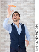 a young businessman jumping trying to reach a carrot. Стоковое фото, агентство Ingram Publishing / Фотобанк Лори