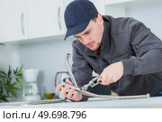 portrait of a male worker replacing the taps connection. Стоковое фото, агентство Ingram Publishing / Фотобанк Лори